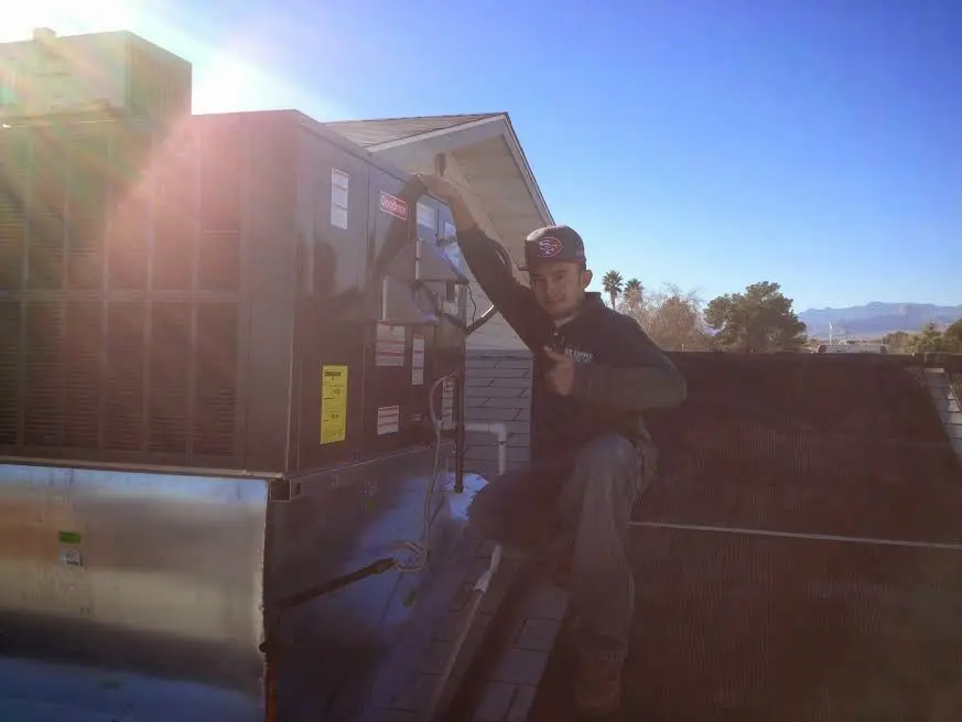 HVAC technician performing AC Tune-Up on a rooftop unit in Fraser